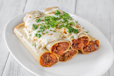 Delicate cannelloni pasta, generously filled with rich bolognese sauce, baked under a blanket of melted mozzarellaの写真素材