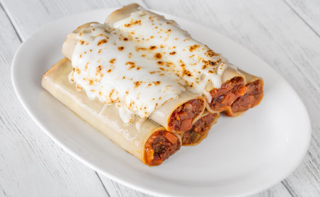 Delicate cannelloni pasta, generously filled with rich bolognese sauce, baked under a blanket of melted mozzarellaの写真素材