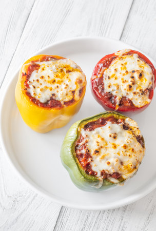 Vibrant bell peppers are baked to perfection, generously stuffed with rich bolognese sauce, and crowned with melted mozzarellaの写真素材