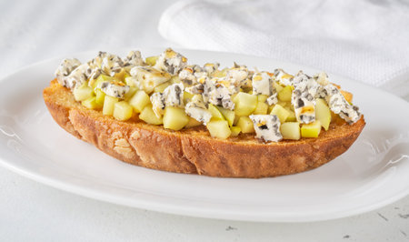 Golden toast hugs melted blue cheese, sweet apples, and warm honey drizzleの写真素材