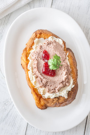 Toasted wheat sandwich with pate, creamy cheese, and tart cranberry jamの写真素材