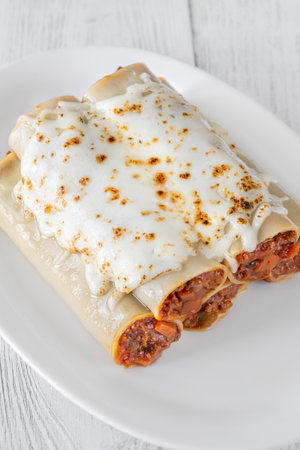 Delicate cannelloni pasta, generously filled with rich bolognese sauce, baked under a blanket of melted mozzarellaの写真素材