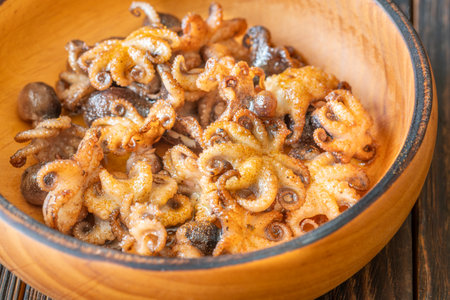 Tender baby octopuses crisped and fragrant, nestled warmly with crunchy garlic finishの写真素材