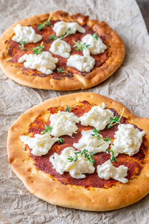 Golden crusts cradle warm stracciatella and sauce, accented with sprigs of thymeの写真素材