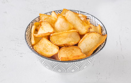Crispy fried dippers rest warmly in bowl, perfect for salty snacking joyの写真素材
