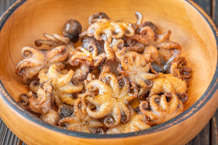 Tender baby octopuses crisped and fragrant, nestled warmly with crunchy garlic finishの写真素材