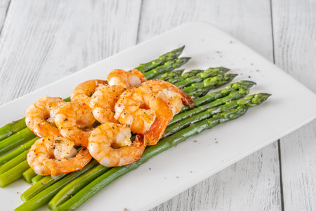 Golden shrimp add crunch and color to soft green spears of asparagusの写真素材
