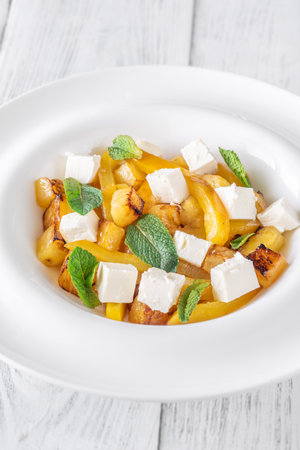 Sweet pineapple, grilled peppers, feta cubes, and mint mingle in vibrant saladの写真素材