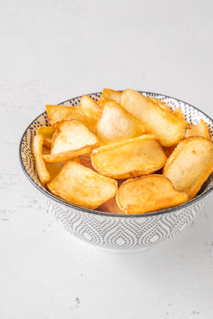 Crispy fried dippers rest warmly in bowl, perfect for salty snacking joyの写真素材