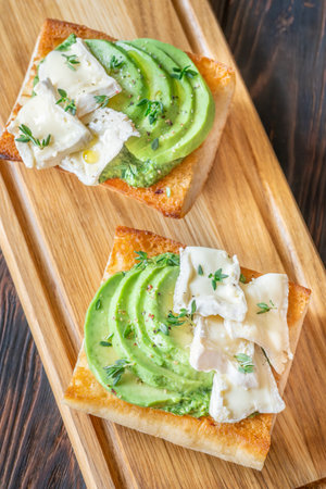 Toasted ciabatta sandwiches layered with brie, avocado, and creamy spinach, delicately herbedの写真素材