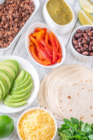 Tortillas surrounded by vibrant toppings and fillings, ready to assemble flavorful tacosの写真素材