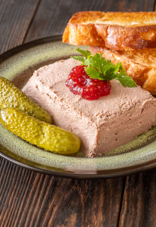 Lush pate paired with tart jam, crispy toast, and briny pickled vegetablesの写真素材