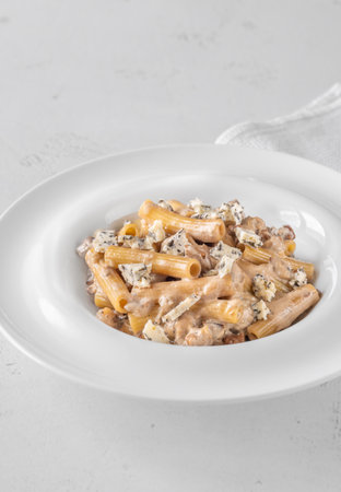 Soft penne coated in rich walnut sauce with crumbled sharp blue cheeseの写真素材