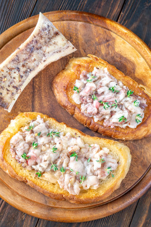 Herb-topped marrow melts into toasted bread, offering bold and buttery rustic indulgenceの写真素材