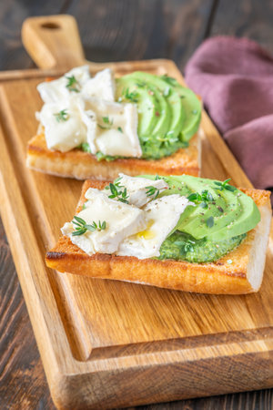 Toasted ciabatta sandwiches layered with brie, avocado, and creamy spinach, delicately herbedの写真素材