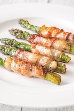 Golden bacon crisps around tender asparagus spears, savory and satisfying combinationの写真素材