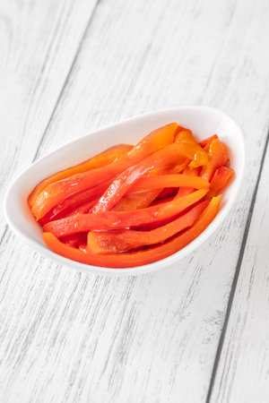Charred red pepper strips arranged in bowl, smoky and sweet flavor showcasedの写真素材