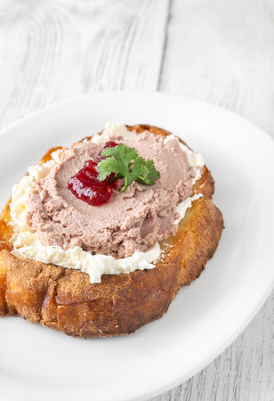 Toasted wheat sandwich with pate, creamy cheese, and tart cranberry jamの写真素材