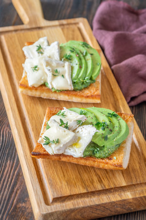 Toasted ciabatta sandwiches layered with brie, avocado, and creamy spinach, delicately herbedの写真素材