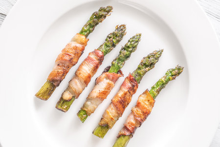Golden bacon crisps around tender asparagus spears, savory and satisfying combinationの写真素材
