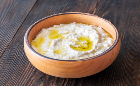 Roasted eggplant dip topped with chili flakes and oil in rustic settingの写真素材
