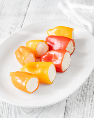 Red, orange, yellow peppers filled with creamy cheeseâa crisp, vibrant appetizer treatの写真素材