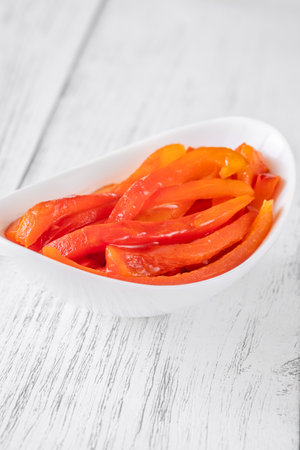 Charred red pepper strips arranged in bowl, smoky and sweet flavor showcasedの写真素材