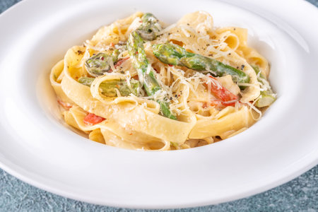 Silky noodles wrapped in sauce, crisp vegetables and cheese complete this comfort dishの写真素材