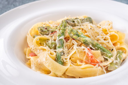 Silky noodles wrapped in sauce, crisp vegetables and cheese complete this comfort dishの写真素材