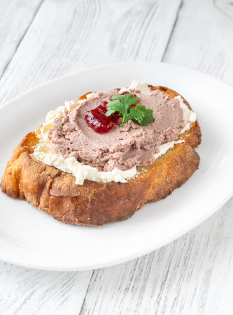 Toasted wheat sandwich with pate, creamy cheese, and tart cranberry jamの写真素材