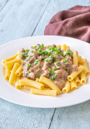 Creamy beef stroganoff over rigatoni, rich sauce, tender meat, and herbsの写真素材