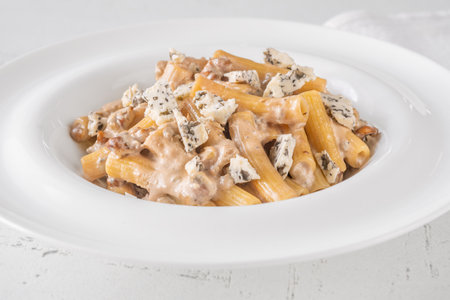 Soft penne coated in rich walnut sauce with crumbled sharp blue cheeseの写真素材