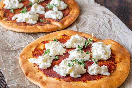 Golden crusts cradle warm stracciatella and sauce, accented with sprigs of thymeの写真素材