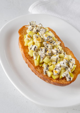 Golden toast hugs melted blue cheese, sweet apples, and warm honey drizzleの写真素材
