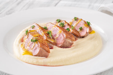Duck breast slices drizzled with lemon mustard sauce and thyme on mashの写真素材