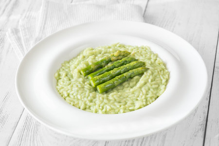 Creamy risotto with green asparagus tips, garnished and beautifully presentedの写真素材