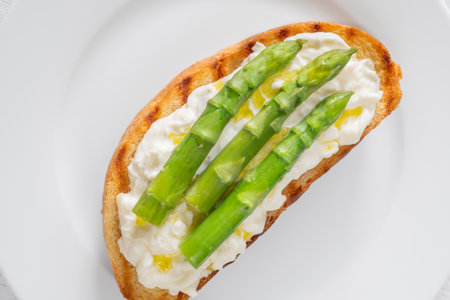 Toasted sandwich filled with creamy stracciatella and crisp asparagus spearsの写真素材