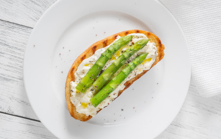 Toasted sandwich filled with creamy stracciatella and crisp asparagus spearsの写真素材
