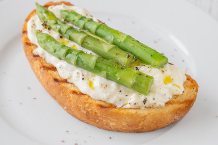 Toasted sandwich filled with creamy stracciatella and crisp asparagus spearsの写真素材