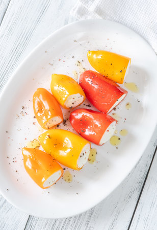 Red, orange, yellow peppers filled with creamy cheeseâa crisp, vibrant appetizer treatの写真素材
