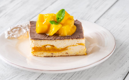 Luscious cheesecake with mango pulp and chocolate glaze, crowned with fresh mangoの写真素材