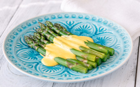 Blue Plate of Boiled Asparagus Drizzled in Silky Hollandaise Sauceの写真素材