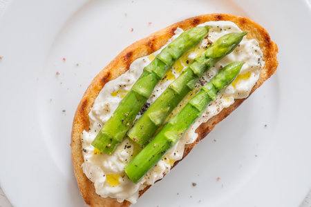 Toasted sandwich filled with creamy stracciatella and crisp asparagus spearsの写真素材