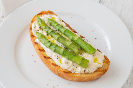 Toasted sandwich filled with creamy stracciatella and crisp asparagus spearsの写真素材