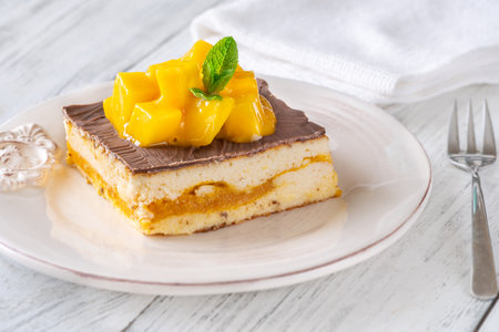 Luscious cheesecake with mango pulp and chocolate glaze, crowned with fresh mangoの写真素材