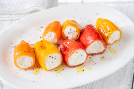 Red, orange, yellow peppers filled with creamy cheeseâa crisp, vibrant appetizer treatの写真素材