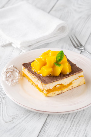 Luscious cheesecake with mango pulp and chocolate glaze, crowned with fresh mangoの写真素材