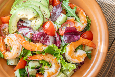 Vibrant salad prawns avocado fresh greens citrus dressing wooden table rusticの写真素材