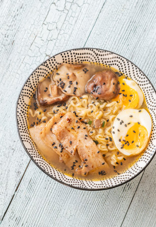 Steam rises over rich broth, tender pork, and golden yolk in comforting harmonyの写真素材