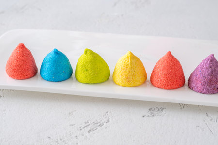 Bright cone-shaped sweets shimmer with crystal sugar texture in a playful confectionery display